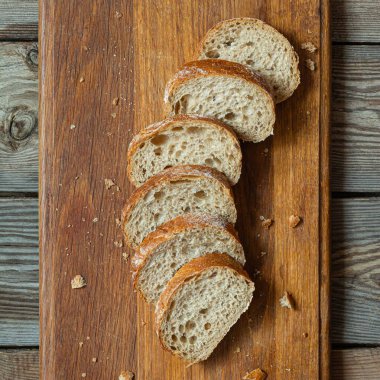 Tahta zemin üzerinde taze pişmiş karabuğday (tam tahıl) ekmeği. Hassas bir ekmek kırıntısı ve çıtır ekmek. Ekşi hamurlu ciabatta. Mayasız pişmiş yiyecekler..