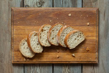 Tahta zemin üzerinde taze pişmiş karabuğday (tam tahıl) ekmeği. Hassas bir ekmek kırıntısı ve çıtır ekmek. Ekşi hamurlu ciabatta. Mayasız pişmiş yiyecekler..