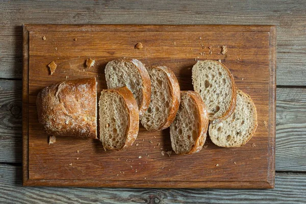 Tahta zemin üzerinde taze pişmiş karabuğday (tam tahıl) ekmeği. Hassas bir ekmek kırıntısı ve çıtır ekmek. Ekşi hamurlu ciabatta. Mayasız pişmiş yiyecekler..