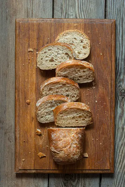 Tahta zemin üzerinde taze pişmiş karabuğday (tam tahıl) ekmeği. Hassas bir ekmek kırıntısı ve çıtır ekmek. Ekşi hamurlu ciabatta. Mayasız pişmiş yiyecekler..