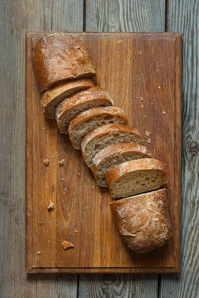 Tahta zemin üzerinde taze pişmiş karabuğday (tam tahıl) ekmeği. Hassas bir ekmek kırıntısı ve çıtır ekmek. Ekşi hamurlu ciabatta. Mayasız pişmiş yiyecekler..