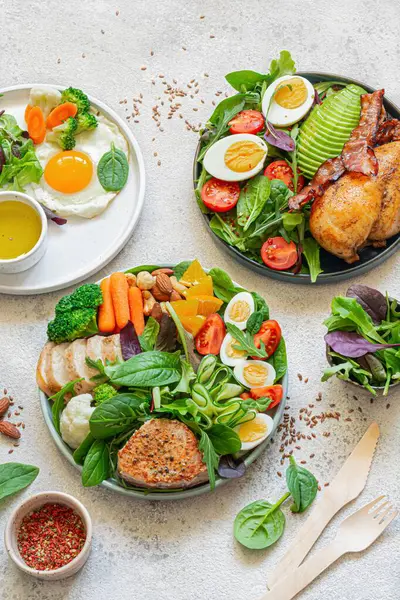 Vegetable plates with meat, fish and eggs. Complete diet for the day. Various breakfasts, lunches, snacks. Time to eat healthy foods. Eating by the hour. Health concept.