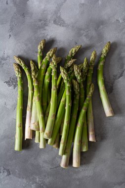 Gri arka planda taze kuşkonmaz filizleri. Sağlıklı beslenme kavramı. Vejetaryenlik. Sebze lif bakımından zengindir, doğal bir prebiyotiktir..