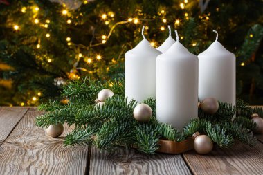 Dört beyaz mumlu sarı çelenk, ahşap arka planda köknar dalları. Pazar Aralık. Geleneksel diy Noel dekorasyonu, tatil geçmişi.