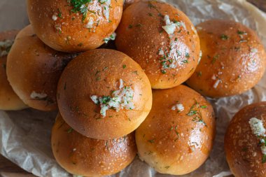 Freshly baked buns (pampushki) with garlic and dill for the first course (soup)on a wooden board. National Ukrainian dish, food. Selective focus. clipart