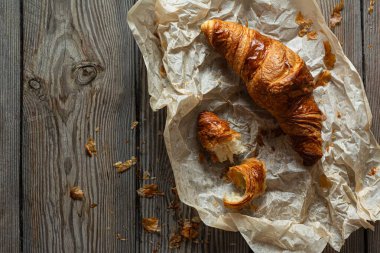 Ahşap arka planda çıtır çıtır Fransız kruvasanları. Kahvaltı için geleneksel poğaça (çörek), lezzetli tatlı..