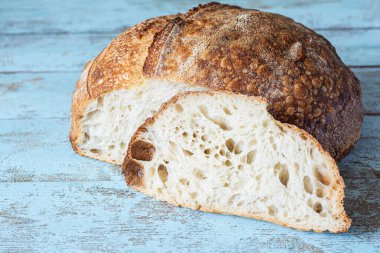 Mavi arka planda ev yapımı taze ekşi ekmek. Çıtır Fransız ekmeği, tam buğday unlu..