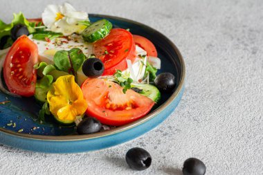 Peynirli iştah açıcı salata, taze sebze (domates, salatalık, soğan), çıtır marul, mikroyeşillik ve menekşe çiçeği. Standart olmayan Yunan salatası servisi.