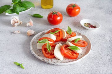 Caprese salad with juicy tomatoes, fresh mozzarella and pesto. Concept for a tasty and healthy appetizer, flat lay. Italian food, cuisine.