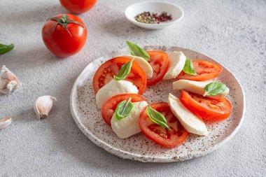 Caprese salad with juicy tomatoes, fresh mozzarella and pesto. Concept for a tasty and healthy appetizer, flat lay. Italian food, cuisine.