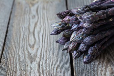 Koyu ahşap arka planda bir demet taze kuşkonmaz. Sağlıklı gıda konsepti. Sebze lif bakımından zengindir, doğal bir prebiyotiktir..