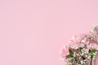 Köşedeki pembe arka planda beyaz çingene buketi ve pembe karanfiller.