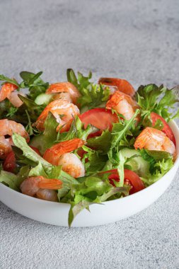 Sebzeli taze çıtır salata ve beyaz bir tabakta karides. Sağlıklı gıda konsepti.