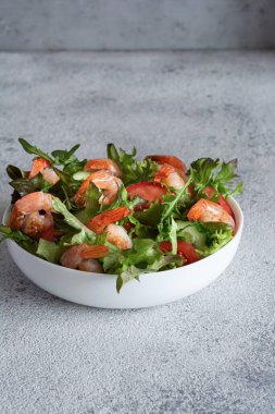 Sebzeli taze çıtır salata ve beyaz bir tabakta karides. Sağlıklı gıda konsepti.