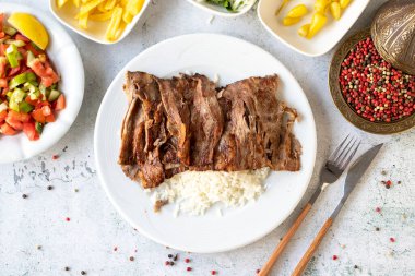 Gri arka planda pirinçli et donörü. Geleneksel tatlar. Biftek ve kuzudan yapılmış çörek kebabı. Üst görünüm