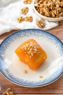 Ahşap zeminde Türk balkabağı tatlısı. Geleneksel Türk mutfağı lezzetleri. Yerel adı Kabak Tatlisi. Kapat.