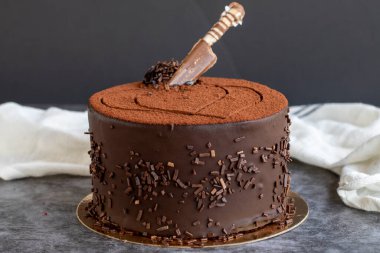 Koyu arkaplanda çikolatalı doğum günü pastası. Kapat.