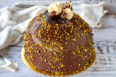 Çam fıstığı ve çikolatalı kek, ahşap arka planda. Doğum günü ve kutlama pastası. Fırın ürünleri. Kapat.