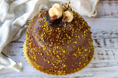 Çam fıstığı ve çikolatalı kek, ahşap arka planda. Doğum günü ve kutlama pastası. Fırın ürünleri. Kapat.