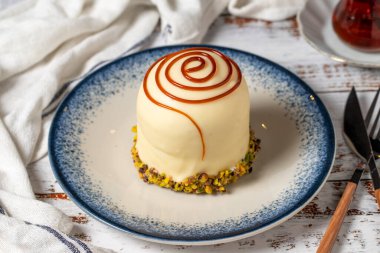 Beyaz ahşap arka planda şam fıstıklı karamel kek. pastane tatlıları