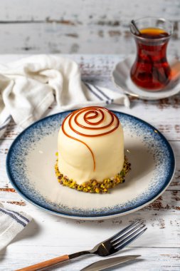 Beyaz ahşap arka planda şam fıstıklı karamel kek. pastane tatlıları