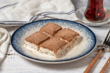 Beyaz ahşap arka planda soğuk baklava. Sütlü ve fıstıklı baklava. Akdeniz mutfağı lezzetlidir. Kapat.