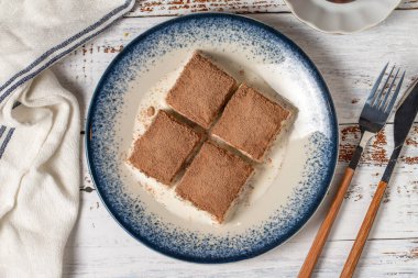 Beyaz ahşap arka planda soğuk baklava. Sütlü ve fıstıklı baklava. Akdeniz mutfağı lezzetlidir. Üst görünüm