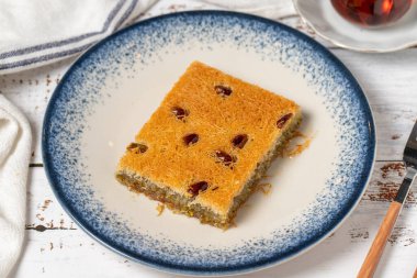 Beyaz ahşap arka planda fıstıklı Kadayif. Akdeniz mutfağı lezzetlidir. Kapat.