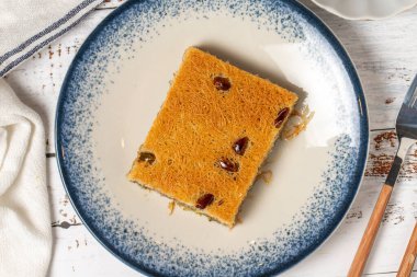 Beyaz ahşap arka planda fıstıklı Kadayif. Akdeniz mutfağı lezzetlidir. Kapat.