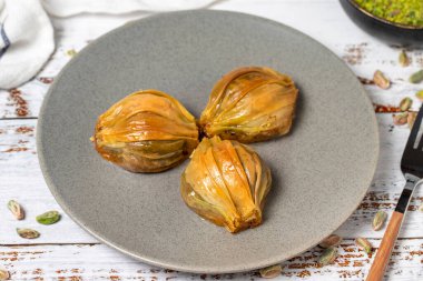 Beyaz ahşap arka planda midye baklavası. Türk mutfağı lezzetleri. Türk baklavası. Kapat.