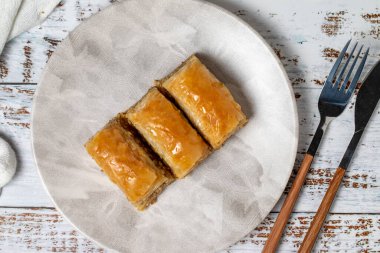 Beyaz ahşap arka planda ceviz baklavası. Türk mutfağı lezzetleri. Türk baklavası. Üst görünüm