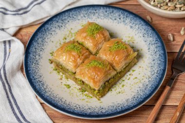 Ahşap arka planda fıstıklı baklava. Türk mutfağı lezzetleri. Türk baklavası. Kapat.