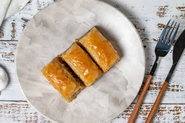 Beyaz ahşap arka planda ceviz baklavası. Türk mutfağı lezzetleri. Türk baklavası. Üst görünüm