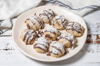 Çikolatalı kurabiye. Fırın ürünleri. Beyaz ahşap arka planda kurabiyeler. Kapat.