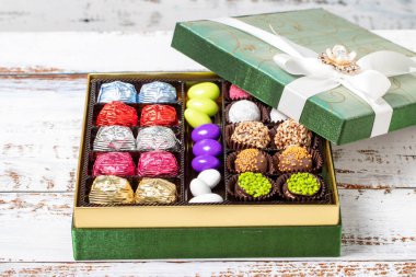 Paketli hediye çikolatası. Ahşap arka planda bir paket karışık çikolata. Kapat.