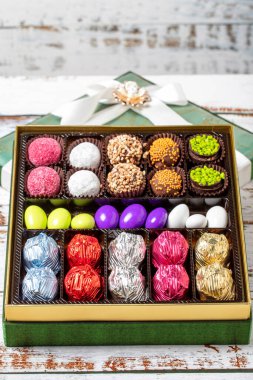 Paketli hediye çikolatası. Ahşap arka planda bir paket karışık çikolata. Kapat.