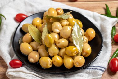 Ahşap arka planda peynirli yeşil zeytin. Lezzetli gurmeler. Kapat.