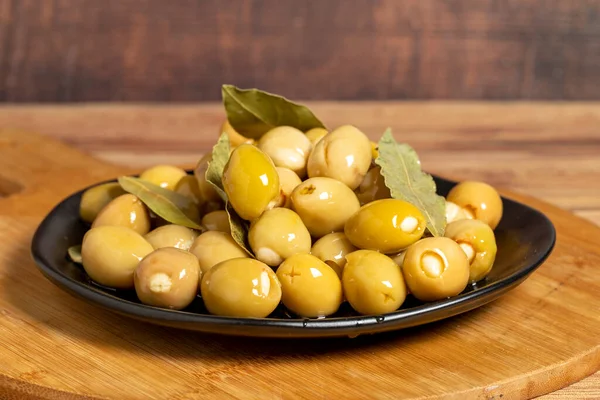 stock image Green olives with cheese filling on a wooden background. Gourmet delicacies. close up