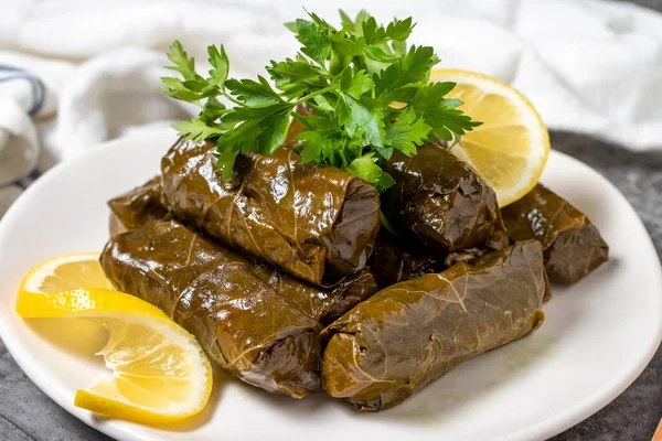 Stuffed leaves with olive oil or dolma on a dark background. Turkish cuisine appetizer flavors. close up