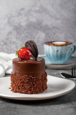 Koyu arkaplanda çikolatalı ve çilekli pasta. Özel kremalı bisküvi, çikolatalı ve kahveli meyveli kek. Fırın ürünleri