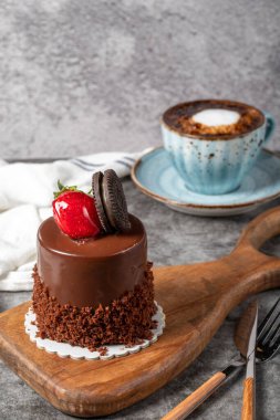 Koyu arkaplanda çikolatalı ve çilekli pasta. Özel kremalı bisküvi, çikolatalı ve kahveli meyveli kek. Fırın ürünleri