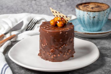 Koyu arkaplanda çikolata ve fındıklı kek. Lezzetli tatlı ve kahveyle. Fırın ürünleri. Kapat.