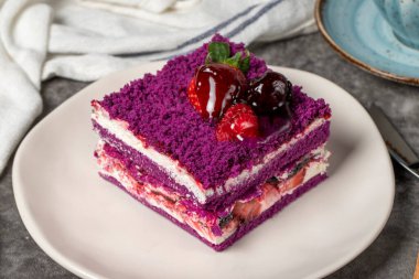 Orman meyveli kek dilimi koyu arkaplanda. Çilek, böğürtlen ve ahududu, siyah dutlu pasta. Fırın ürünleri. Kapat.