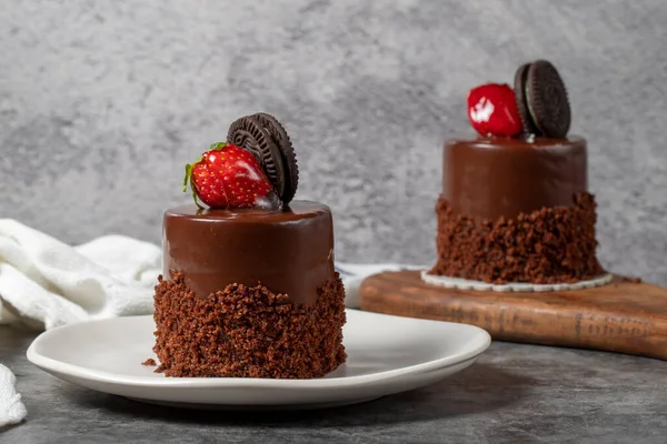 Koyu arkaplanda çikolatalı ve çilekli pasta. Bisküvi, çikolata ve özel kremayla hazırlanmış meyveli pasta. Fırın ürünleri