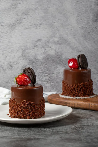 Koyu arkaplanda çikolatalı ve çilekli pasta. Bisküvi, çikolata ve özel kremayla hazırlanmış meyveli pasta. Fırın ürünleri