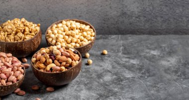 Ceviz, şam fıstığı, fındık ve fındık karışımı koyu bir arka planda bir kasede. Metin için boş alan. Boşluğu kopyala