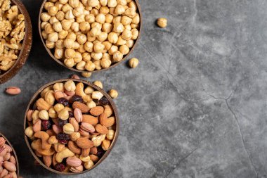 Ceviz, şam fıstığı, fındık ve fındık karışımı koyu bir arka planda bir kasede. Metin için boş alan. kopyalama alanı. Üst görünüm