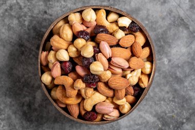 Arka planda kabın içinde fındık var. Hindistan cevizi kasesinde fındık, kaju, badem ve şam fıstığı. Üst görünüm