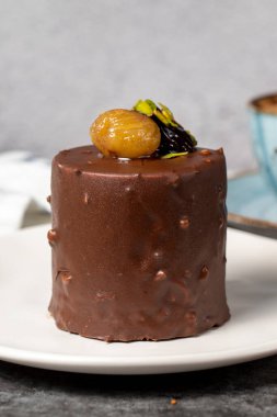 Koyu arkaplanda çikolata ve kestane rengi kek. Kremalı lezzetli pasta. Stüdyo çekimi. Fırın ürünleri. Kapat.