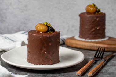 Koyu arkaplanda çikolata ve kestane rengi kek. Kremalı lezzetli pasta. Stüdyo çekimi. Fırın ürünleri. Kapat.